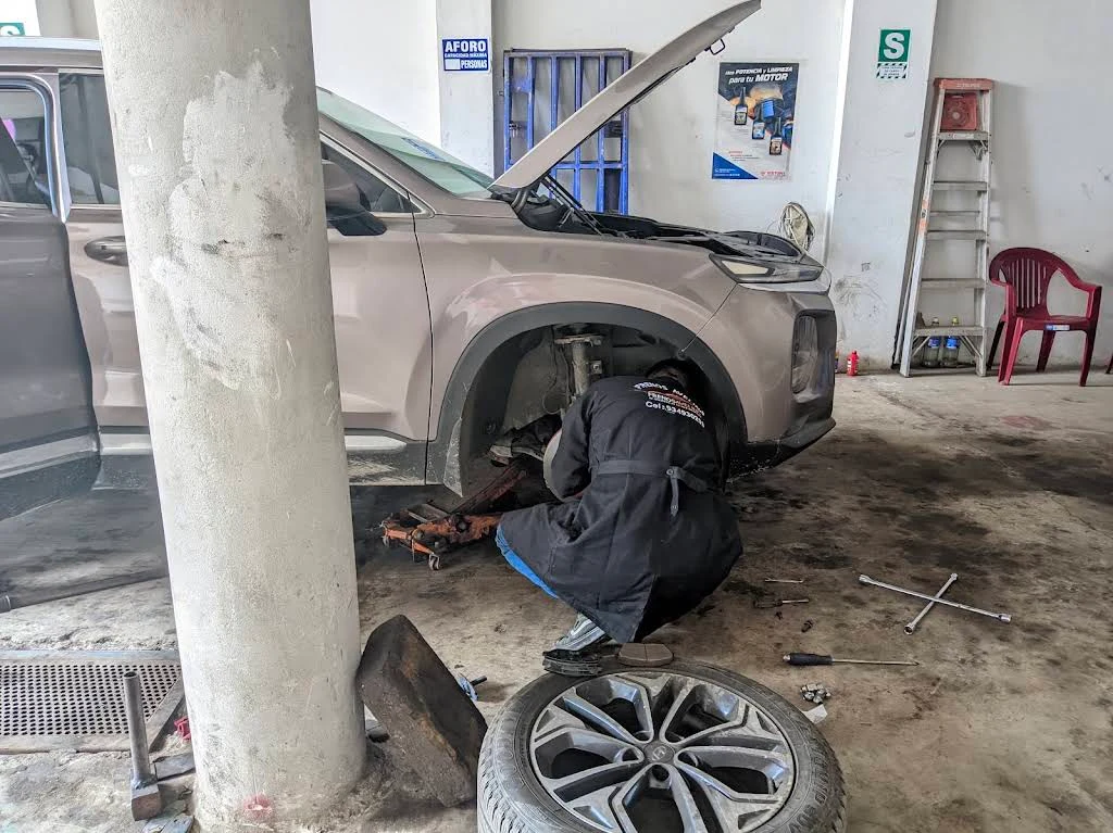 Mecánico trabajando en un vehículo dentro de FRENOS AVELINO